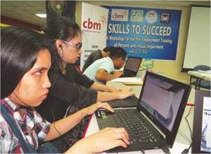 photo: a female student (in the front) and employment skills training workshop participants using laptops