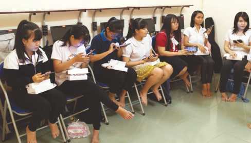 Photo: a group of female trainees receiving and learning the use of tablets
