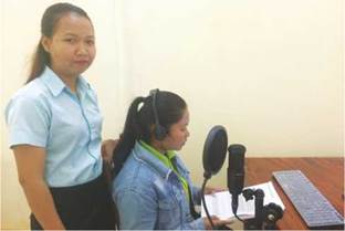 photo: two females with one recording audiobooks and the other looking at the readers