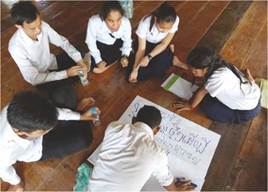 photo: a group of students sitting on the floor in a circle in discussion