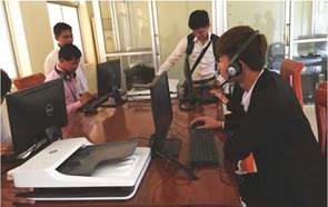 Students support/resource center at Battambang University – students using computers with visitors observing 
