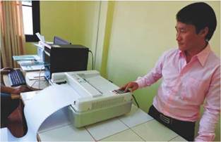 photo: a volunteer from UNoL Inclusive Center printing braille notes